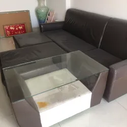 Ghế sofa da nâu đen hình chữ L cao cấp, mặt kính bàn uống nước