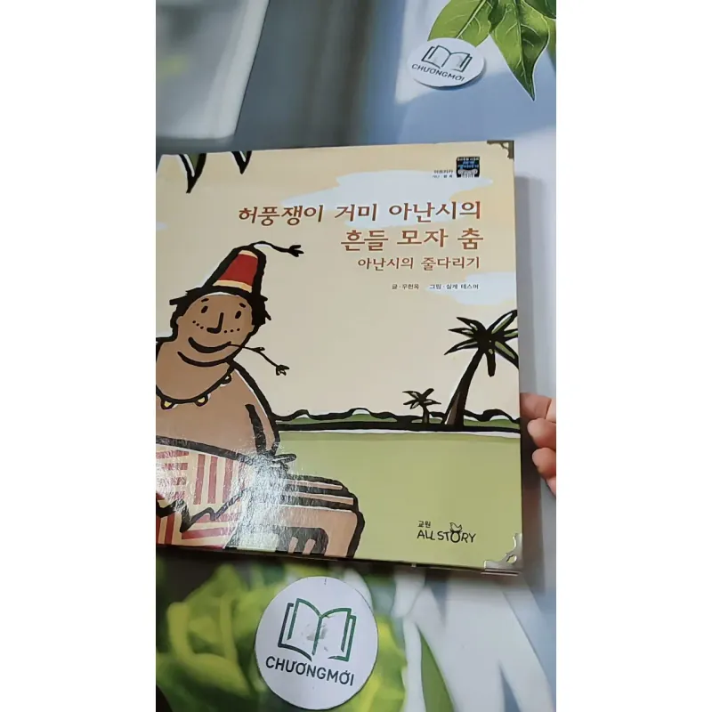 [Tặng nẹp góc] Truyện thiếu nhi Hàn Quốc: Moyamo Anu 57 -  모야모 아누와: 허풍쟁이 거미 아난시의 흔들 모자 춤; 732062