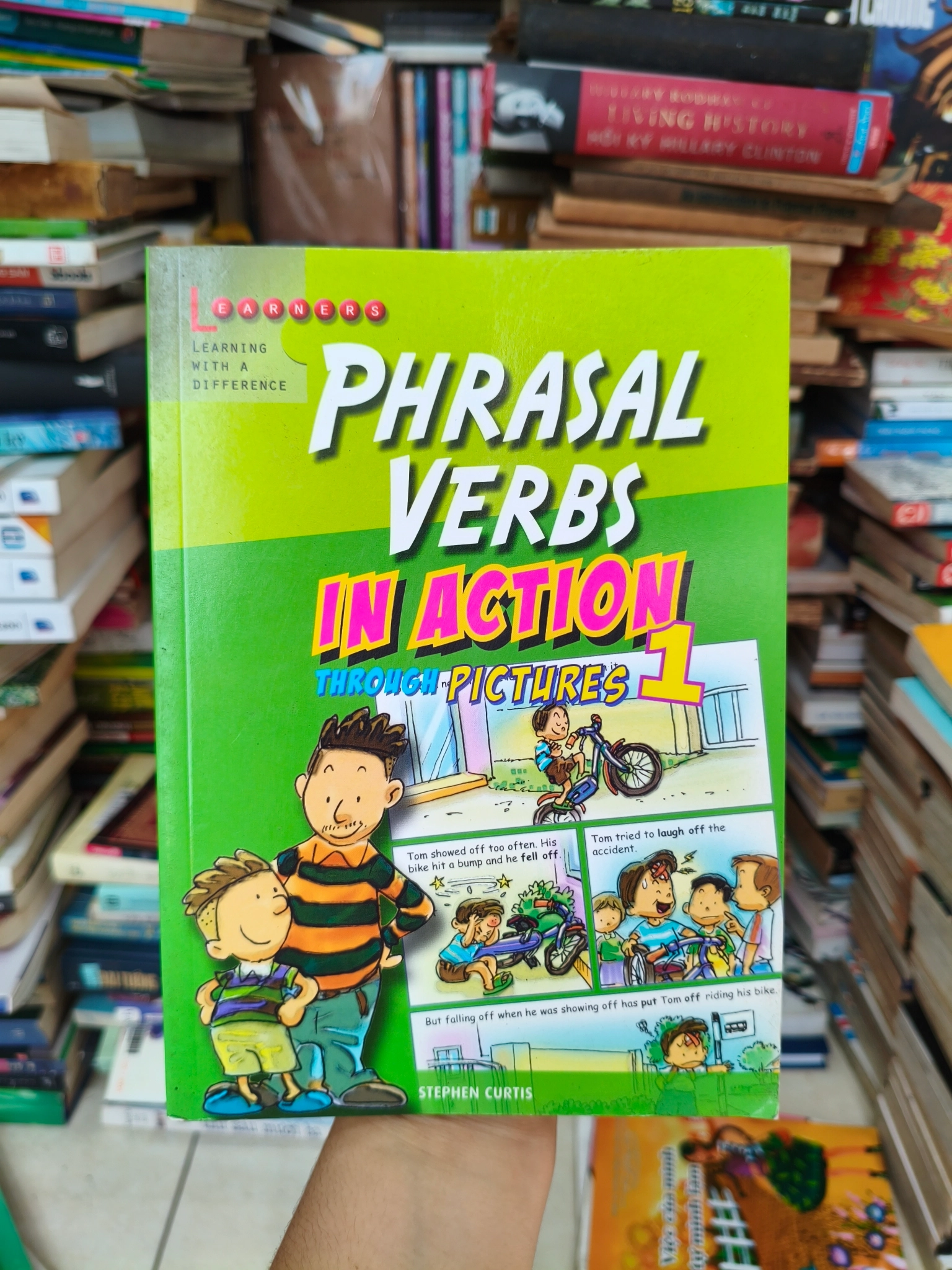 Phrasal verbs in action through pictures 🌱 by  - Sách Book Cover - Ngọc Hiển Books