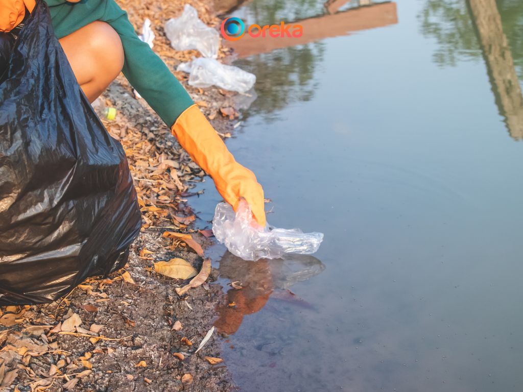 cách bảo vệ môi trường nước, hình ảnh người phụ nữ đang rặt rác thải ni lông vứt vào đúng nơi quy định, qua đó vừa làm sạch môi trường, vừa tăng tính thẩm mỹ cho dòng kênh