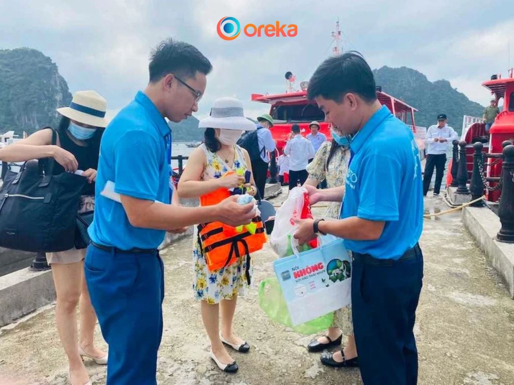 du lịch bền vững, các hướng dẫn viên đang phát dụng cụ làm sạch bãi biển cho du khách tham gia tour du lịch nhặt rác
