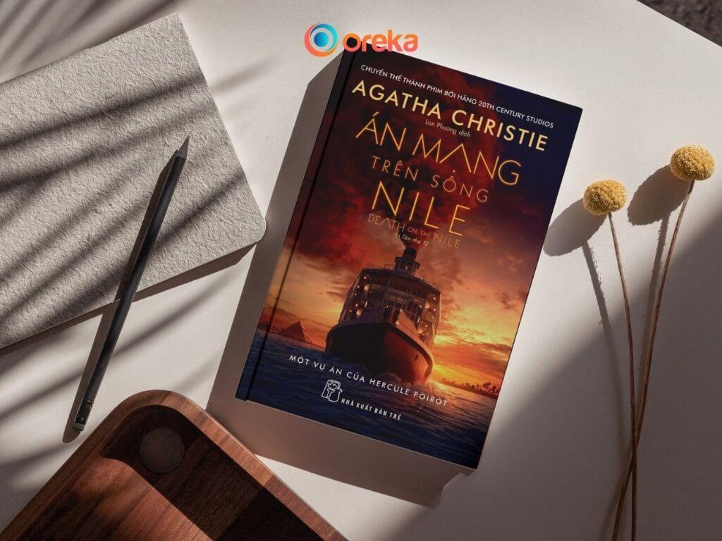 Án Mạng Trên Sông Nile: Review Tiểu Thuyết Trinh Thám Nên Đọc 2 review án mạng trên sông nile. Hình ảnh cuốn sách được đặt trên bàn, bên cạnh có 1 cái bút, 1 cuốn số, 1 góc của khay gỗ và 2 cành hoa khô
