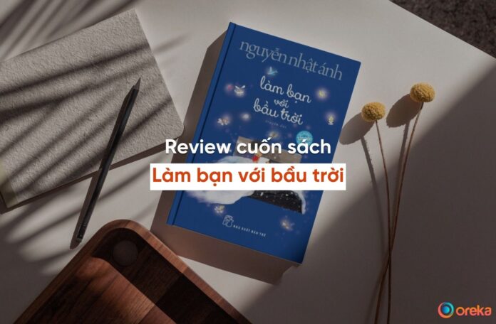 review Làm bạn với bầu trời. Hình ảnh cuốn sách được đặt trên mặt bàn, bên cạnh có 1 cái bút, 1 nửa cuốn sổ, và 1 khay gỗ