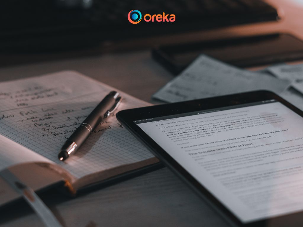 Giải Đáp Từ A-Z: Có Nên Mua Ipad Cũ Để Học Tập Và Giải Trí? 2 Nên mua Ipad cũ nào? Hình ảnh chiếc ipad được đặt trên bàn, bên cạnh có 1 cuốn sổ và 1 cây bút.